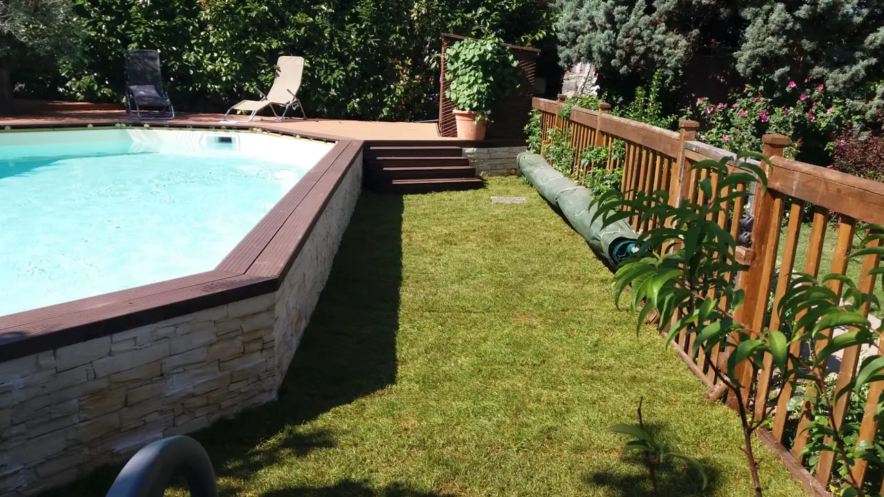 Pelouse posée en plaques au pourtour d’une piscine.